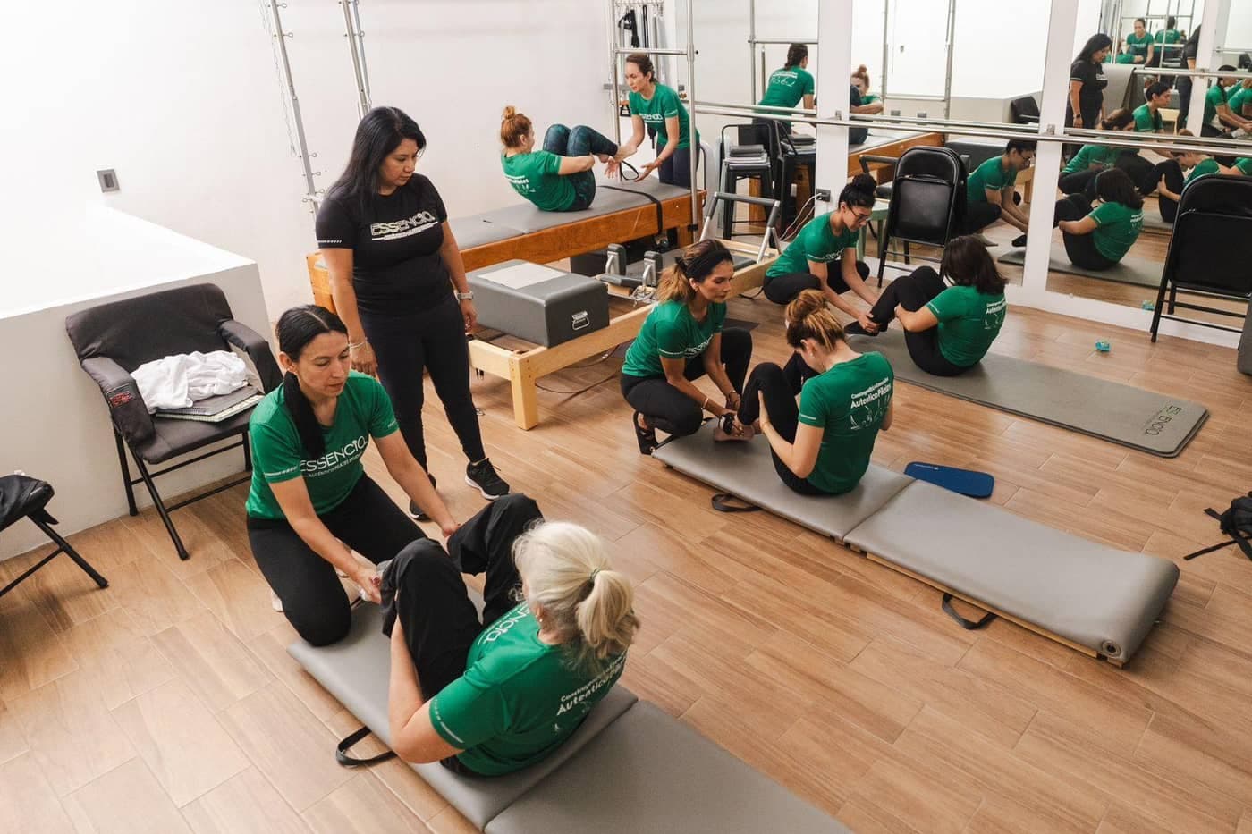 Grupo de alumnas en formación practicando sobre colchoneta en el estudio