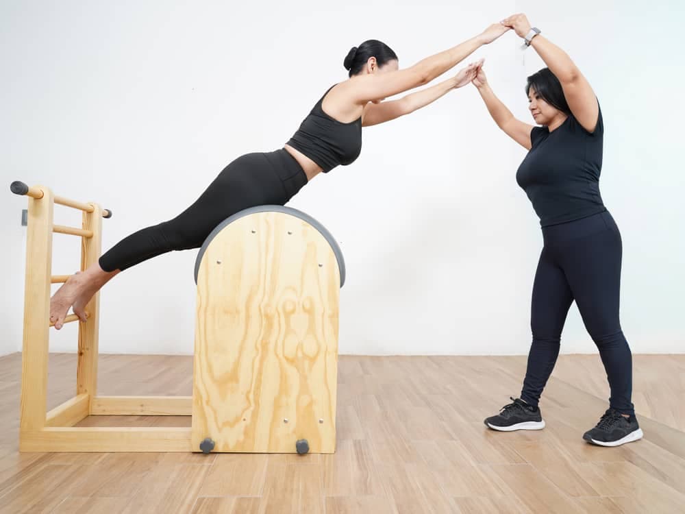 Instructora guiando una extensión sobre el barril en una sesión privada